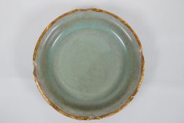 A Chinese celadon glazed porcelain dish with gilt metal lobed rim, chased and gilt character