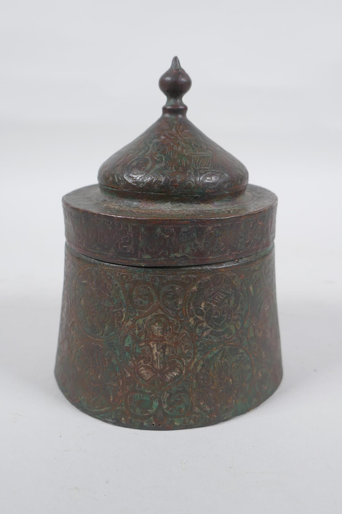 An antique Persian copper ink well with remnants of multi metal inlaid decoration, possibly