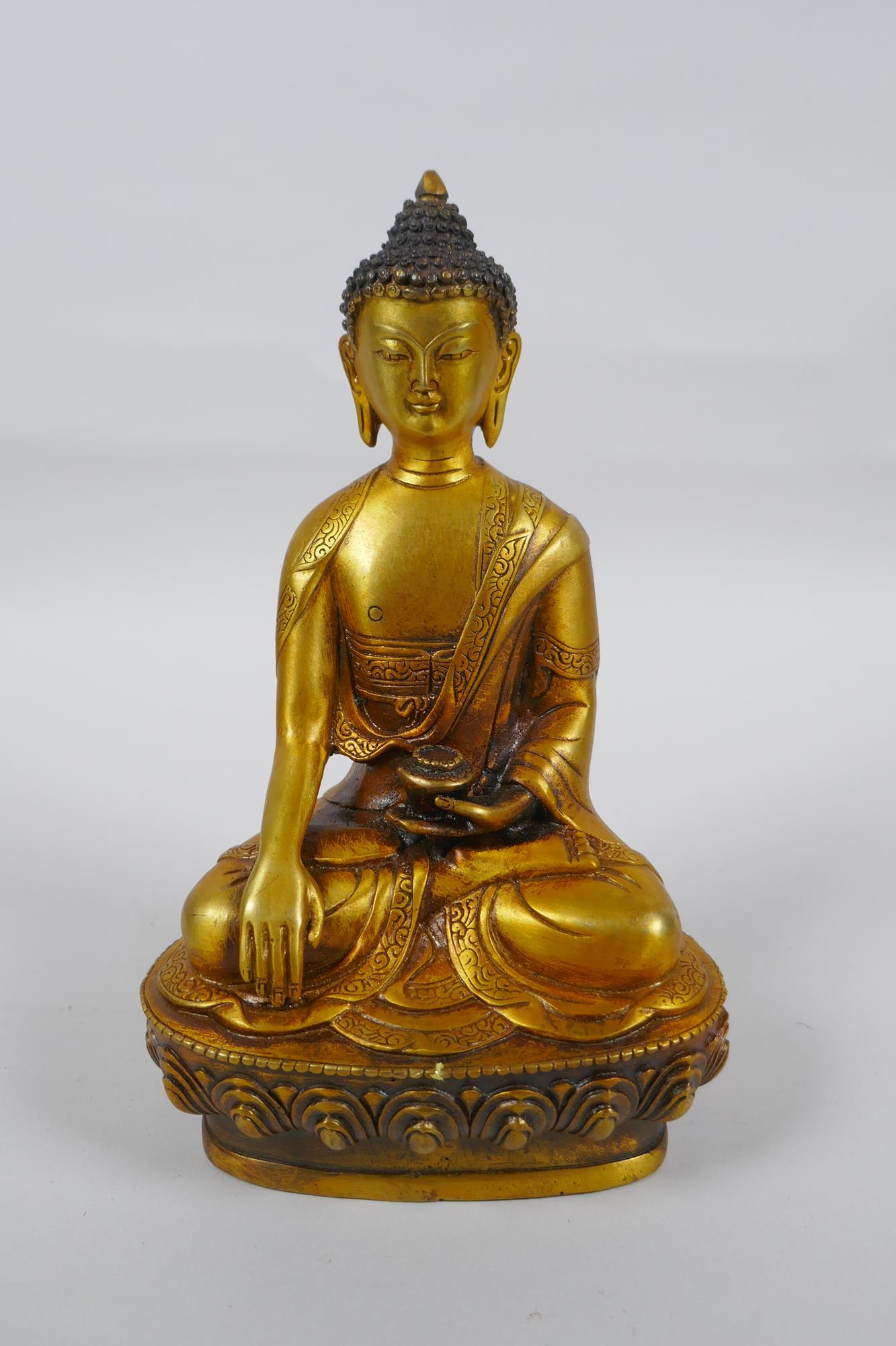 A Tibetan gilt metal Buddha seated in meditation, double vajra mark to base, 20cm high