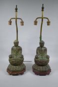 A pair of Chinese bronze Buddha table lamps, with ver de gris patina and wood bases, 62cm high