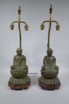 A pair of Chinese bronze Buddha table lamps, with ver de gris patina and wood bases, 62cm high