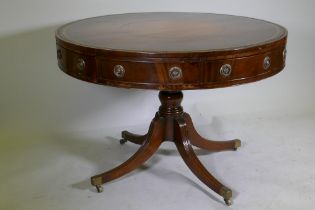 A C19th mahogany drum table, with inset gilt tooled leather top, four true and four false drawers,