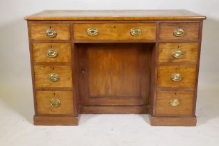 C19th faded mahogany nine drawer knee hole desk, the cupboard with two shelves, brass plate