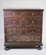 A late C17th.early C18th oak garret chest of four drawers, raised on bun feet, with adaptions, 95