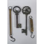 Two antique Salter brass spring balance scales, and two cast iron oversized keys, largest 35cm