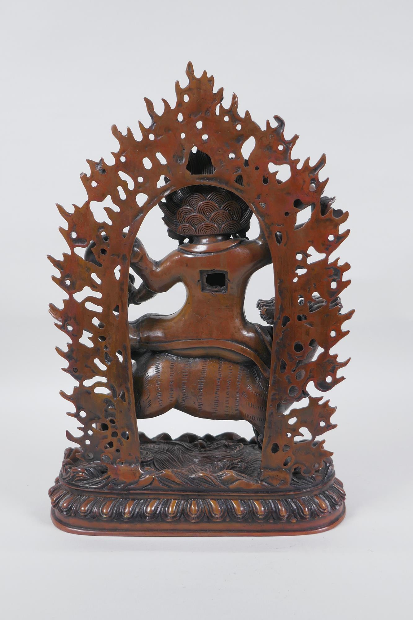 A Tibetan coppered bronze figure of a wrathful deity riding a mythical creature, double vajra mark - Image 4 of 6