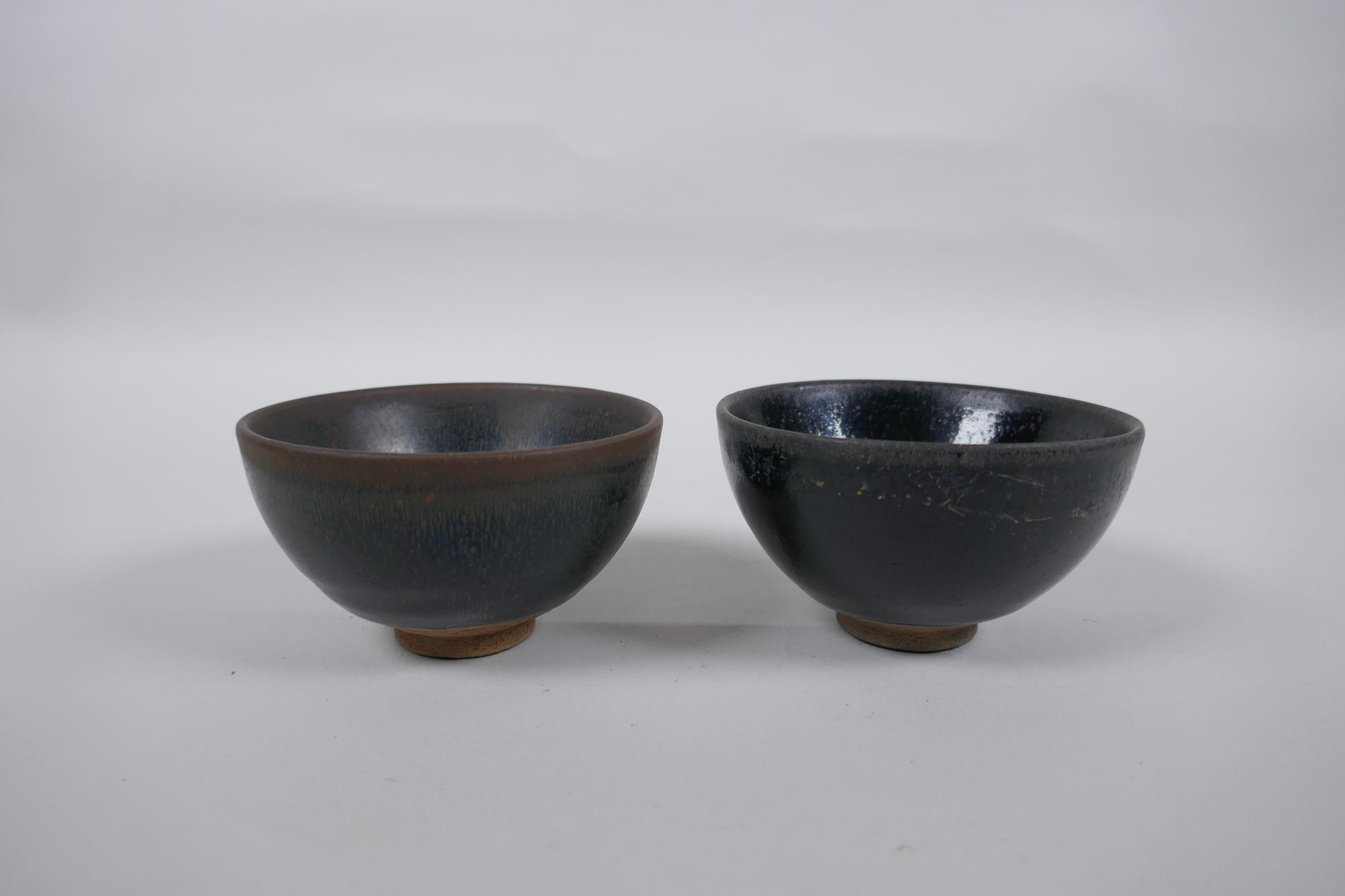 A Chinese Jian Kiln tea bowl with hares fur glaze, and another with a treacle glaze, 9cm diameter