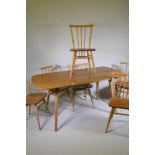 A set of six Ercol model 391 stick back chairs with elm seats, and a dining table, 150cm long