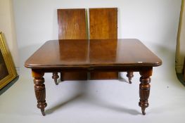 A Victorian walnut dining table, with pull out action and two leaves, raised on turned and reeded