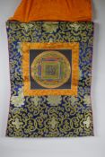 A hand painted Tibetan Mandala, in hanging silk mount, 48 x 58cm