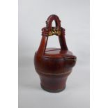 An antique Chinese red lacquered wood basket with spout and carved handle, 40cm high