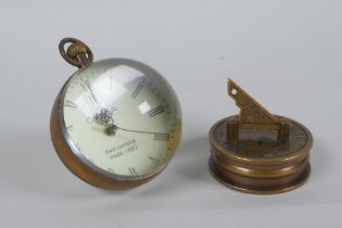 A brass and glass ball desk clock and a Stanley style brass sundial clock and compass, 6cm diameter