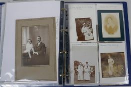 An album of early C20th photographs and cabinet cards, mostly portraits, including a press