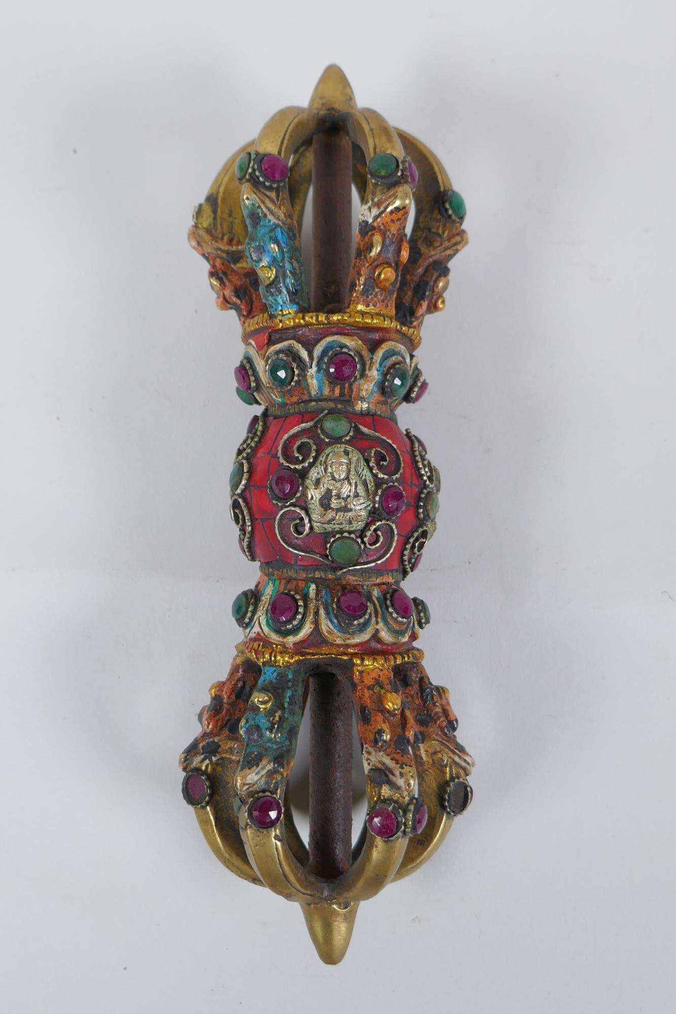 A Tibetan ceremonial bronze vajra with painted details and stone settings, 23cm long