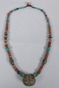 A Tibetan coral, turquoise, banded agate and glass bead necklace with enamelled white metal