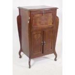An early C20th Art Nouveau style mahogany music cabinet, with fall front and two cupboards, 55 x