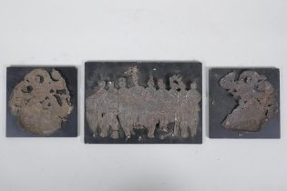 Three Mongolian white metal foil raised figural plaques, on ebonised wood panels, largest 20 x 14cm