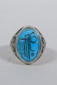 An Islamic white metal ring set with a turquoise intaglio seal, size Q/R
