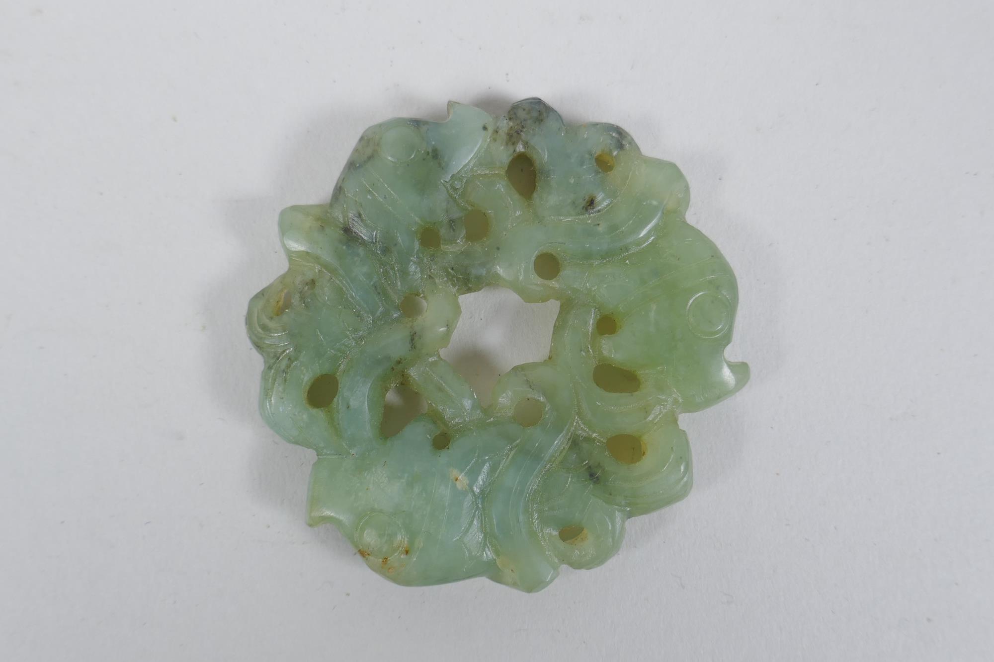 A Chinese carved and pierced mottled green jade pendant with entwined carp decoration, 6cm diameter - Image 2 of 2