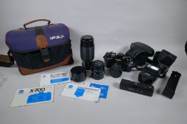 A Minolta X-700 SLR camera fitted with a Soligor zoom and macro 28-55mm lens, and a collection of