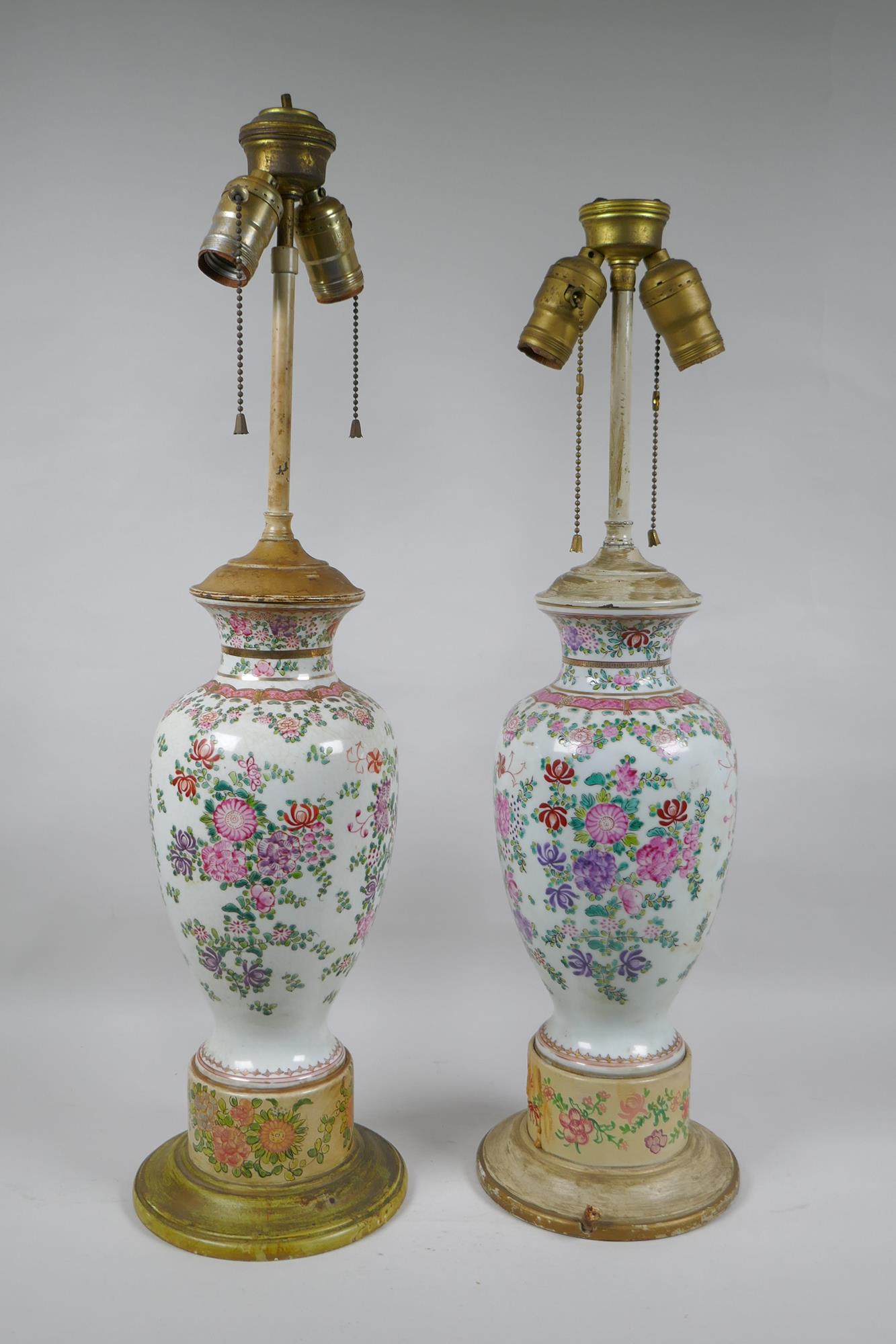 A pair of famille rose porcelain vases converted to lamps, with matching painted bases, 67cm highest