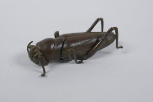 A Japanese Jizai style okimono grass hopper with articulated limbs and wings, 8cm long