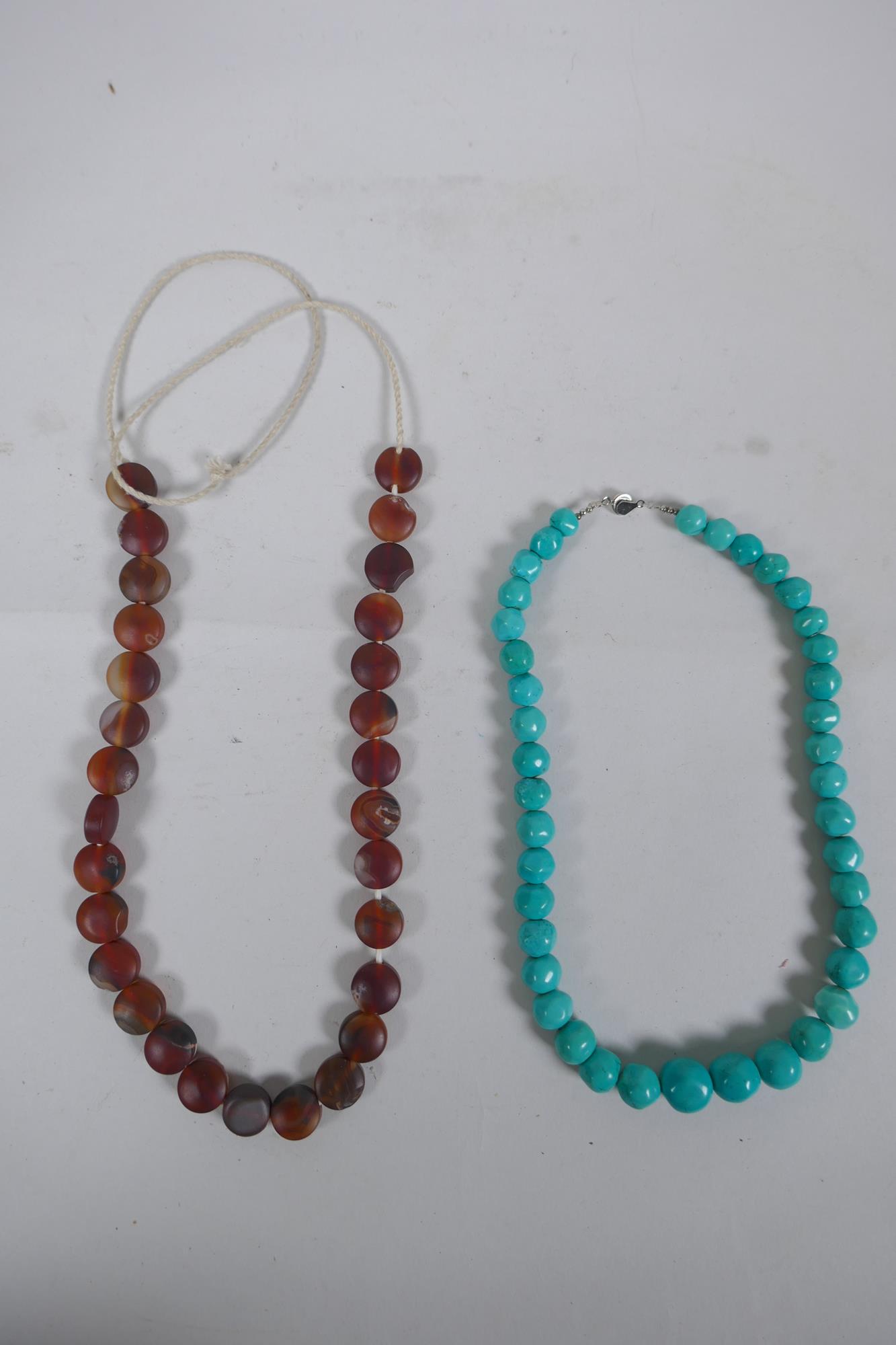 A string of graduated turquoise beads, together with a string of amber agate beads