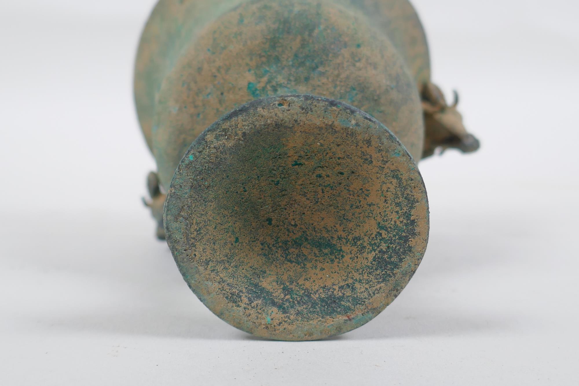 An antique metal goblet with rams head mounts, and green patina, 12cm high - Image 3 of 5