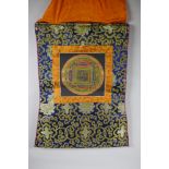 A hand painted Tibetan Mandala, in hanging silk mount, 48 x 58cm