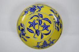 A Chinese imperial yellow ground porcelain dish with blue and white floral decoration, Zhengde 4
