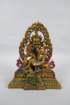 A Tibetan painted and gilt bronze figure of the deity Jambhala, 24cm high