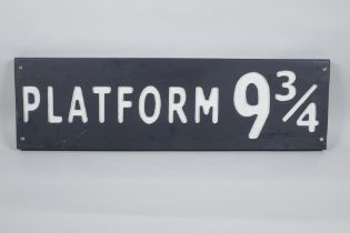 A painted wood Harry Potter 'Platform 9¾' sign, 17 x 59cm long