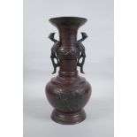 A Chinese bronze vase with two phoenix handles and raised panels depicting dragons, 30cm high