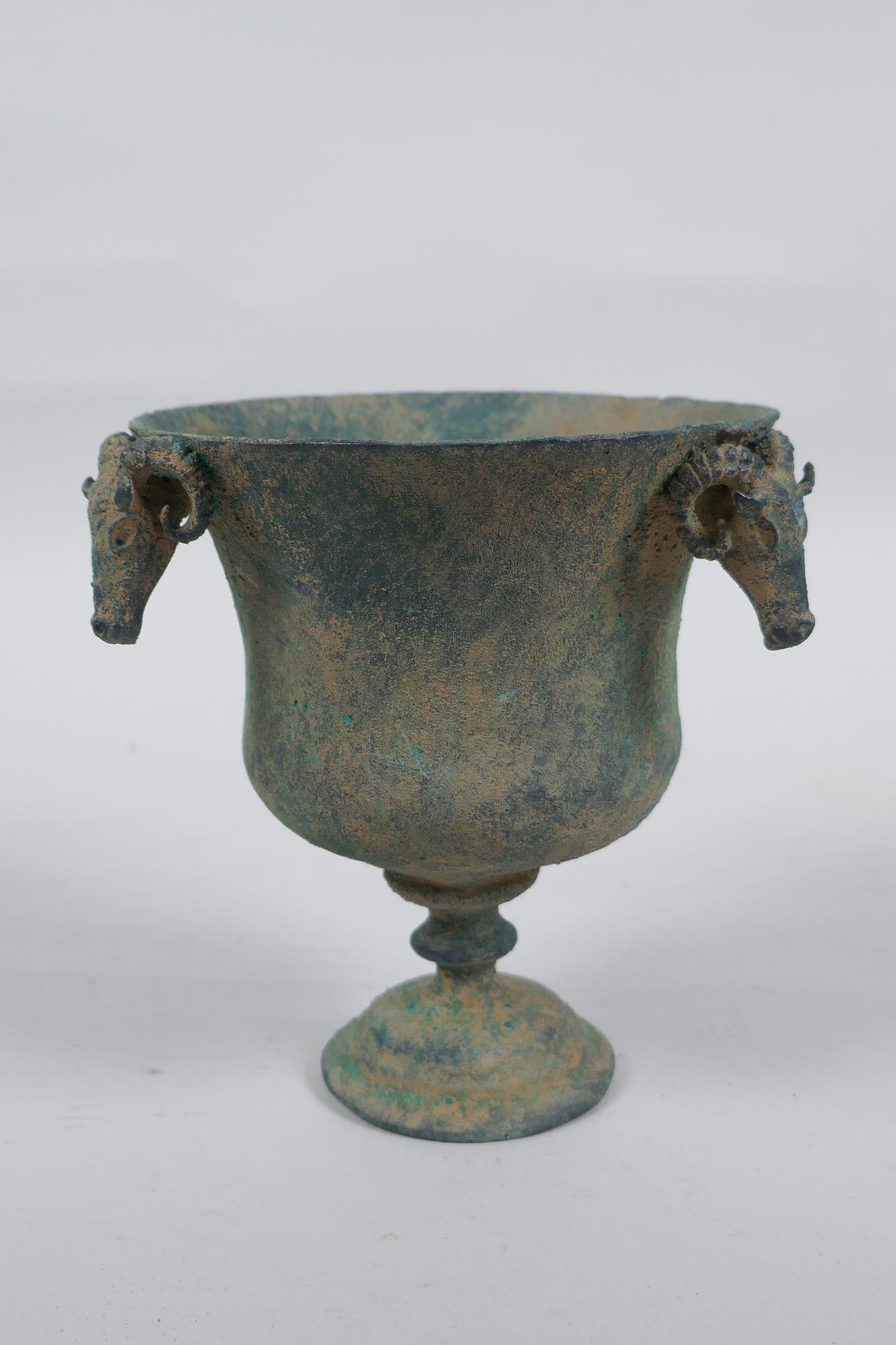 An antique metal goblet with rams head mounts, and green patina, 12cm high - Image 2 of 5
