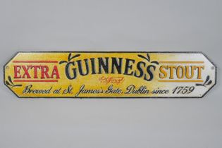 A painted cast iron 'Guinness Extra Stout' advertising sign, 57 x 13cm