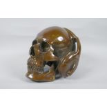 A decorative filled bronze skull wearing headphones, 16cm high