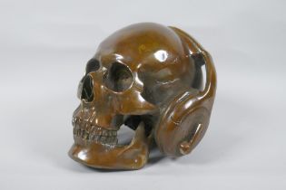 A decorative filled bronze skull wearing headphones, 16cm high
