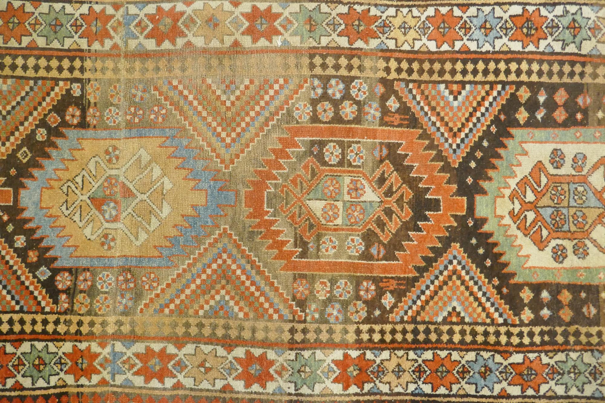 A multi colour ground Kurdish Kazak wool runner with a geometric medallion design on a brown - Image 2 of 6
