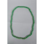 An apple green jade bead necklace, 82cm long