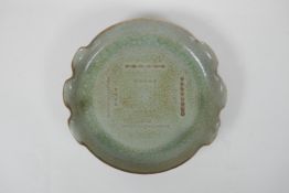 A Chinese celadon crackle glazed porcelain dish with frilled rim, chased character inscription to