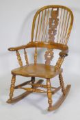 A yew wood hoopback rocking chair with pierced splat and elm seat