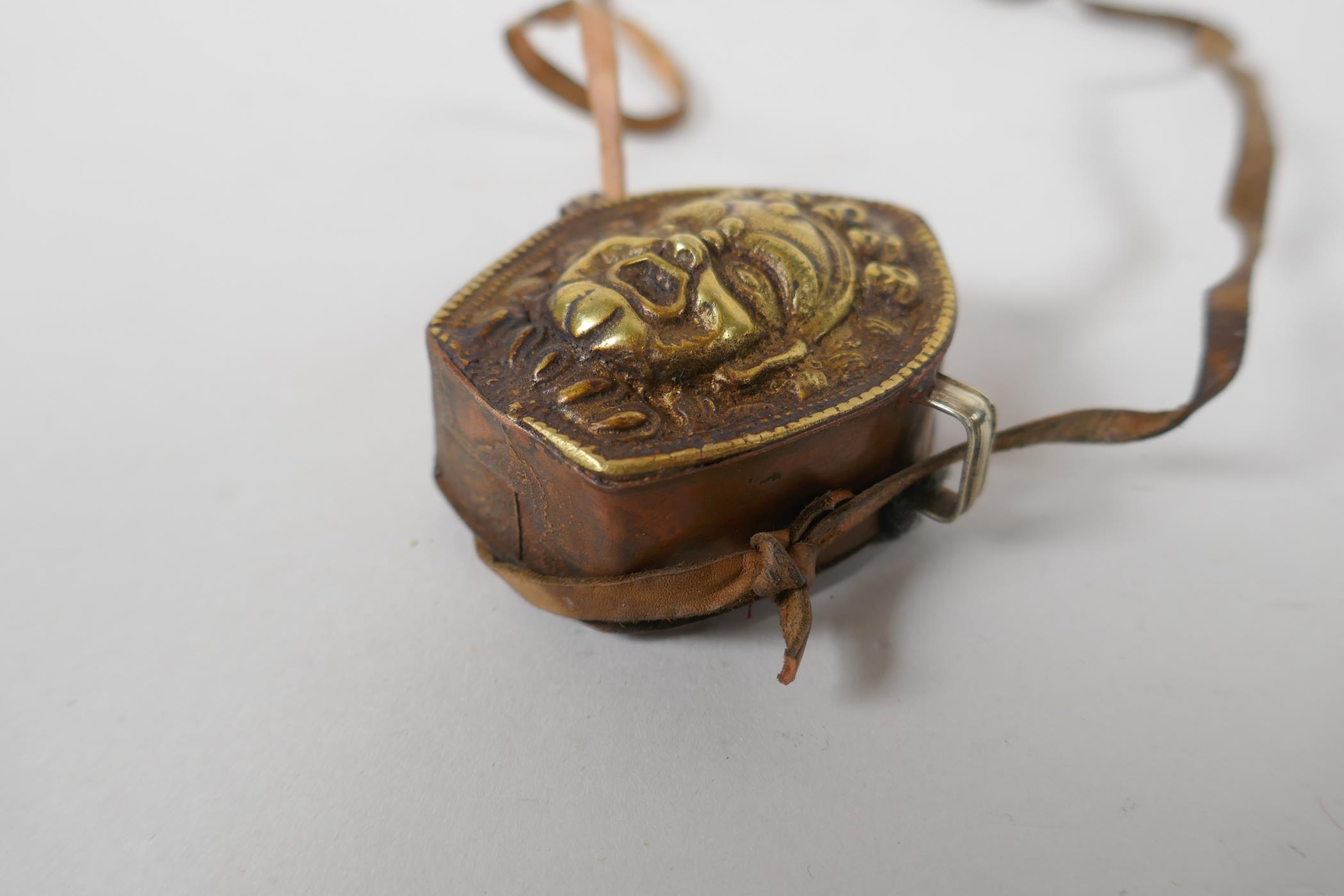 A Tibetan copper and brass Gau box, with repousse wrathful deity mask decoration, 4 x 6cm - Image 3 of 3