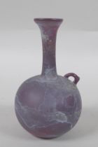 An antique purple glass bottle, 14cm high