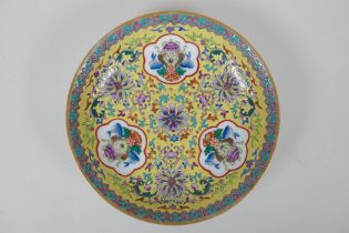 A Chinese polychrome porcelain dish decorated with auspicious symbols and lotus flowers on a