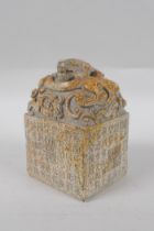 A reconstituted stone seal with dragon decoration to top and allover character inscription, 13cm
