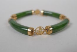 A yellow metal mounted spinach jade bracelet decorated with Chinese characters, marked 14, 18cm long