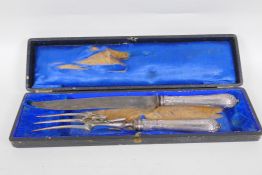 A C19th French silver handled carving knife and fork set, with deer decoration, boxed, 33cm long