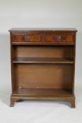 A mahogany open bookcase with two drawers and two adjustable shelves, raised on swept supports, 76 x