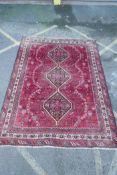 A Persian washed red ground full pile Qashqai tribal carpet, 216 x 294cm