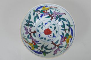 A Chinese porcelain bowl with wucai enamel bird decoration to the interior and incised dragon